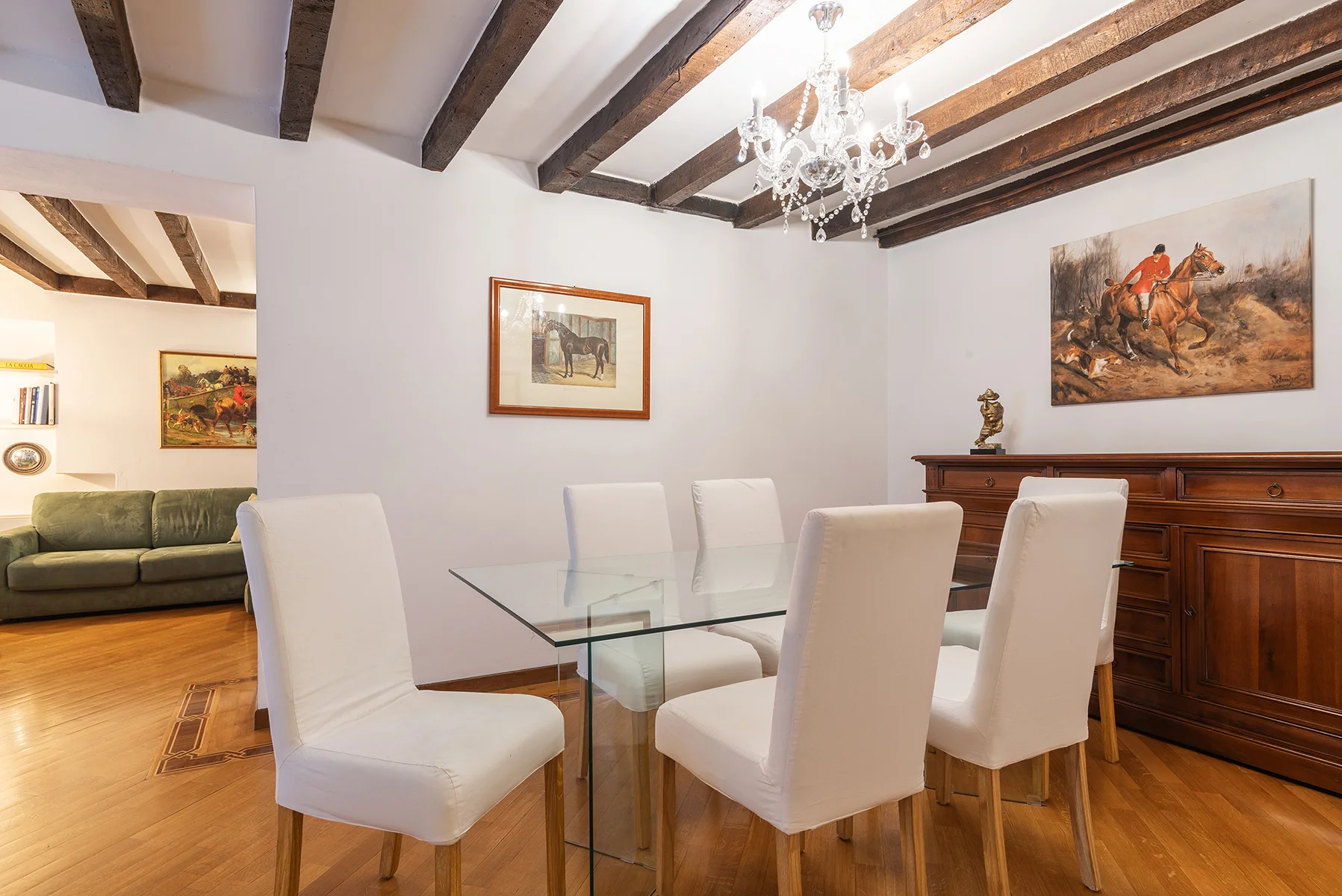 Sala da pranzo elegante con tavolo in vetro e lampadario