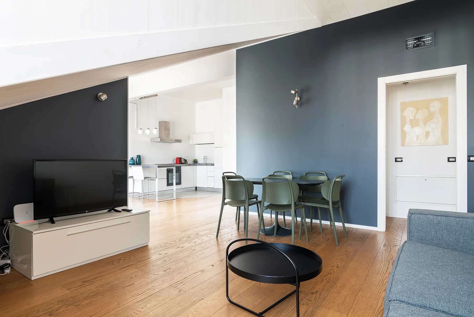 Soggiorno luminoso Brera Luxury Suites con divano blu e parete navy