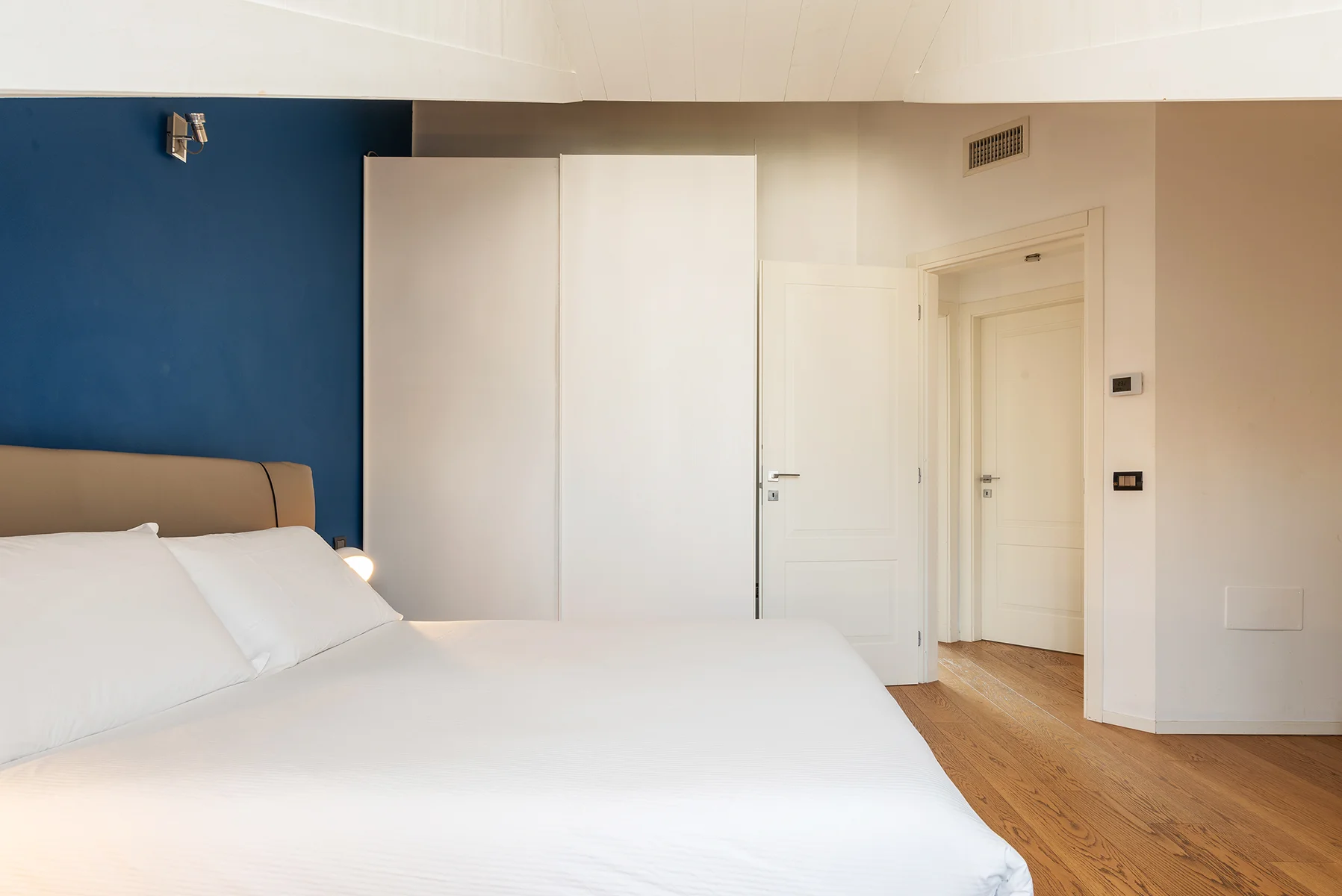 Camera da letto matrimoniale con parete blu Brera Luxury Suites