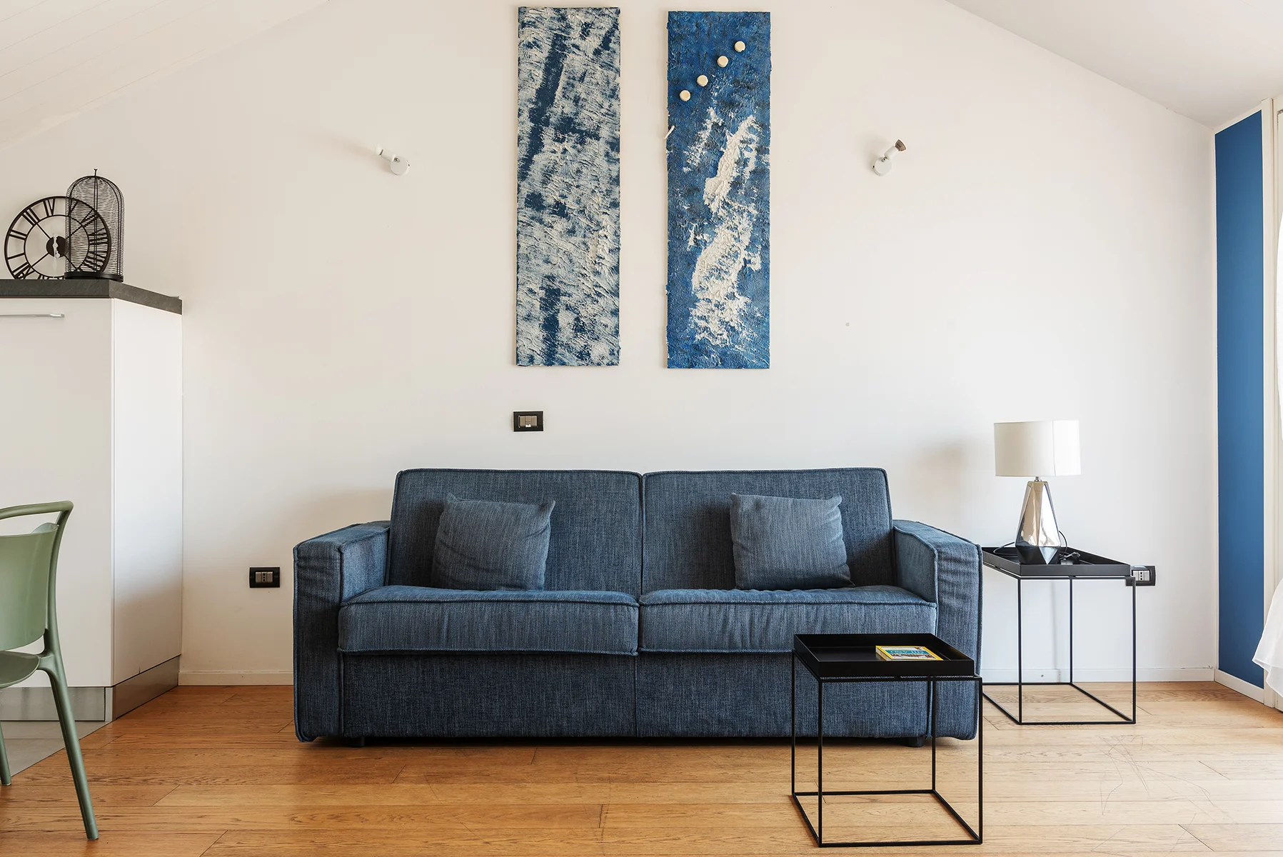 Soggiorno luminoso Brera Luxury Suites con divano blu e parete navy