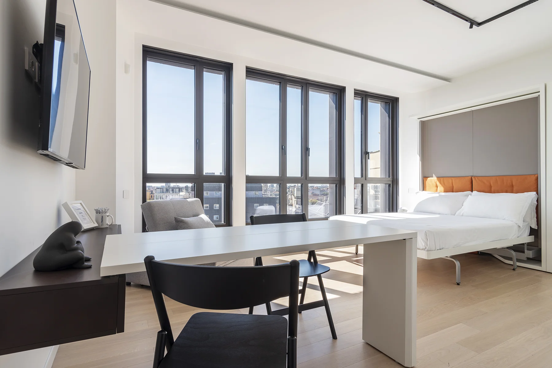 Zona living luminosa con divano e ampie vetrate panoramiche