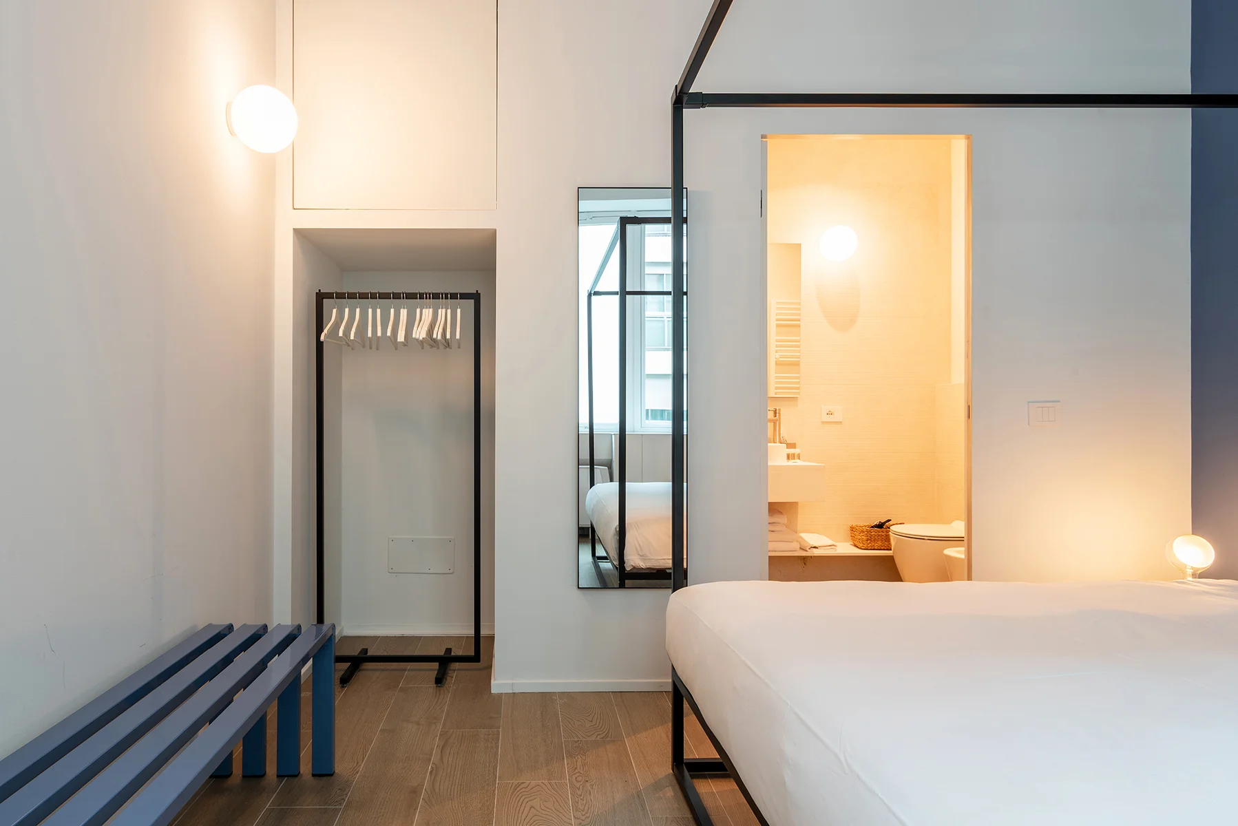 Camera da letto con letto a baldacchino nero e lenzuola bianche