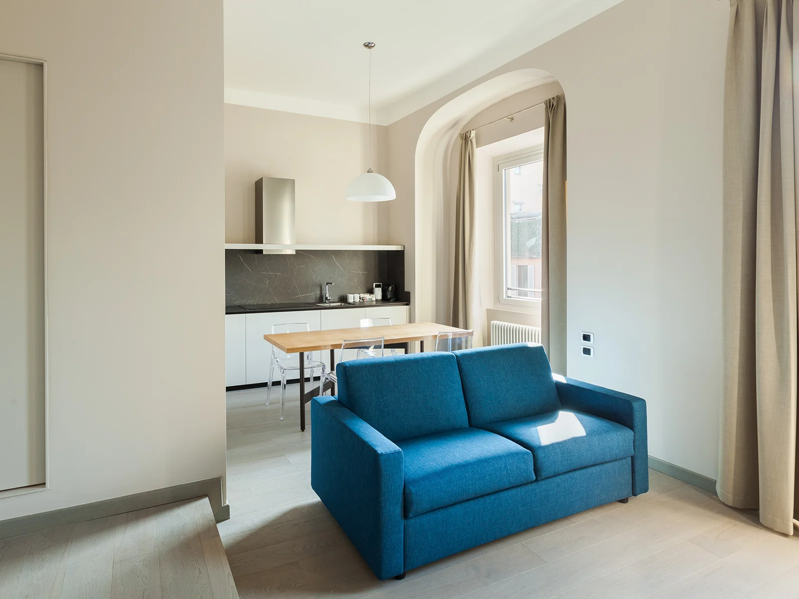 Duomo Suites Bilo Milano - Bilocale luminoso con zona living e divano blu