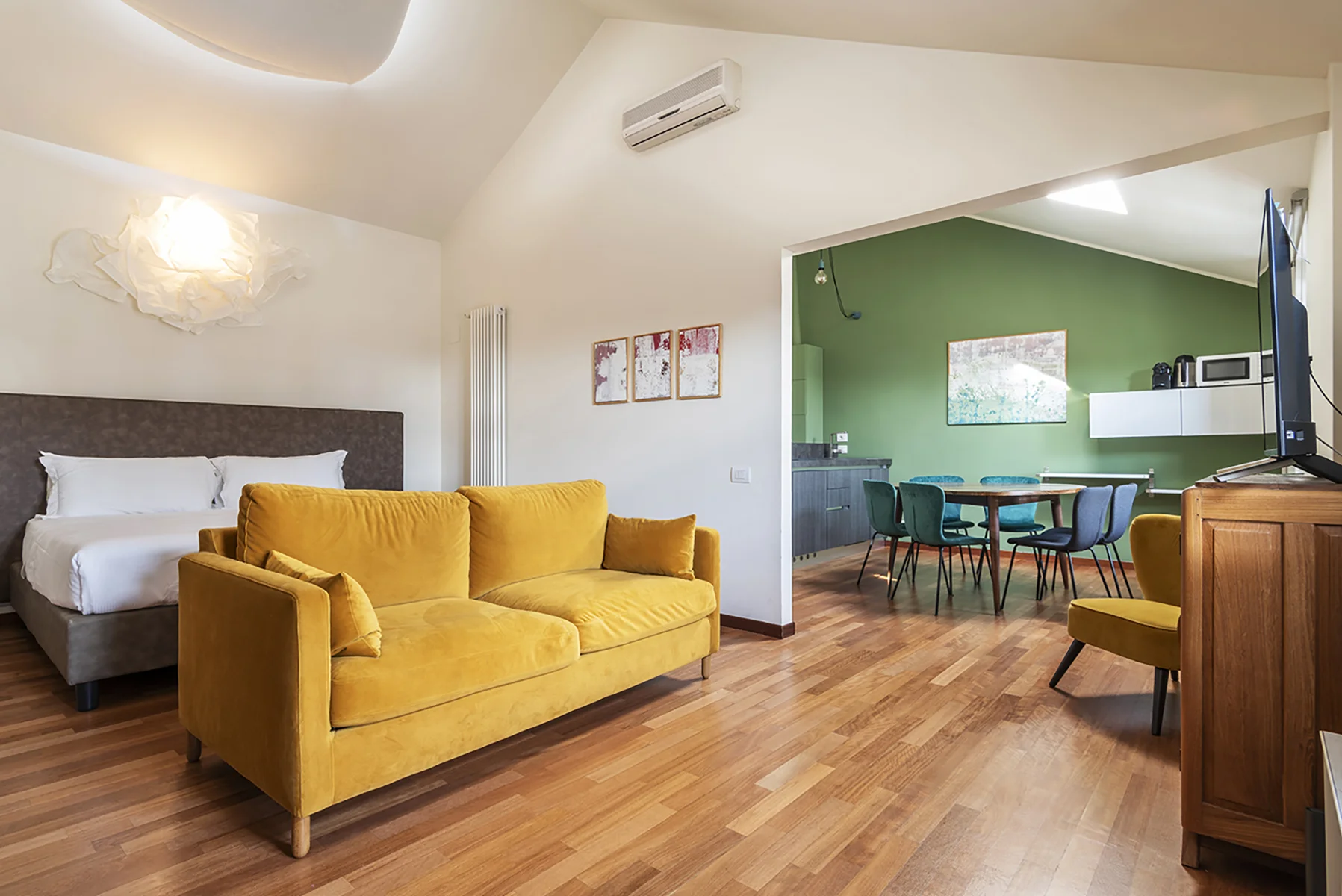 Soggiorno loft Duomo View con divano giallo e tavolo in legno