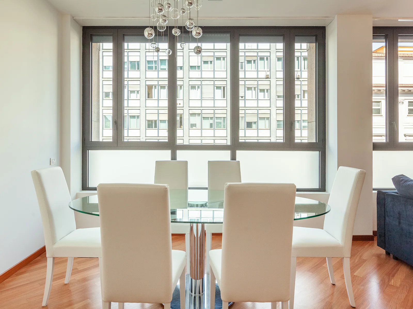 Sala da pranzo con tavolo in vetro e sedie bianche